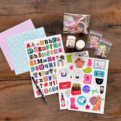 Collection of stationery items including stickers, paper, and small containers on a wooden surface