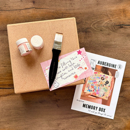 Crafting kit with paint, brush, and decorative items on a wooden surface