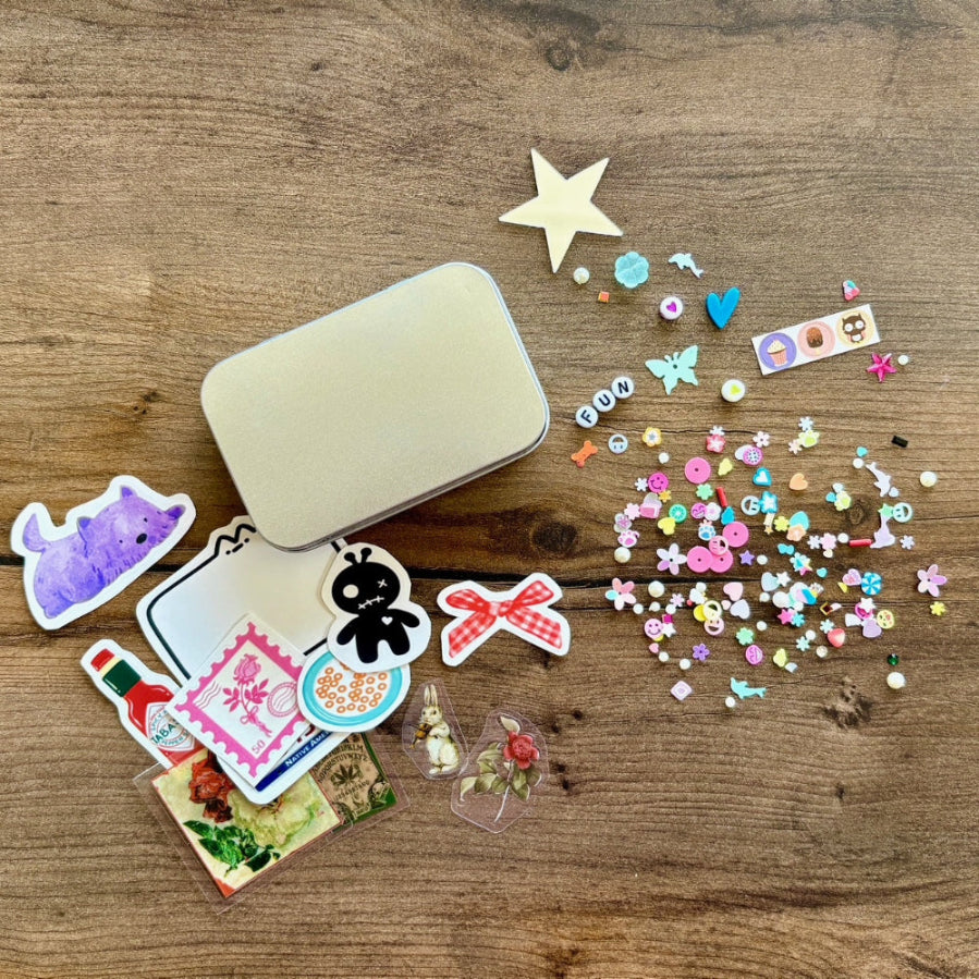 Collection of colorful stickers and a small tin on a wooden surface